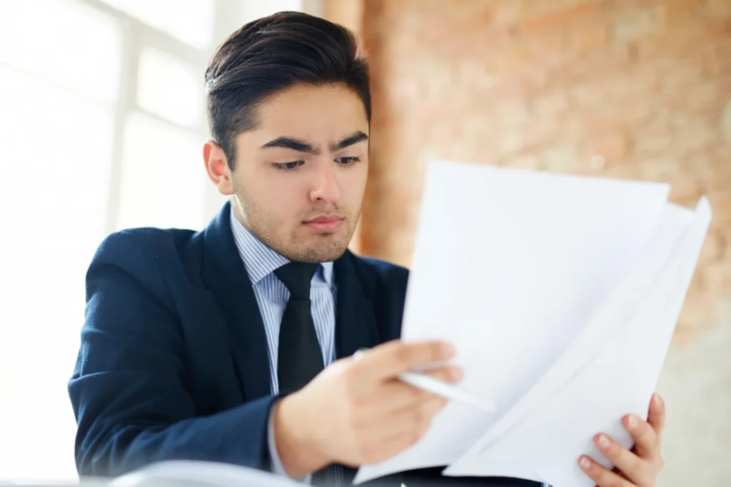 Homem analisando documentos financeiros para pedido de revisão de pensão alimentícia