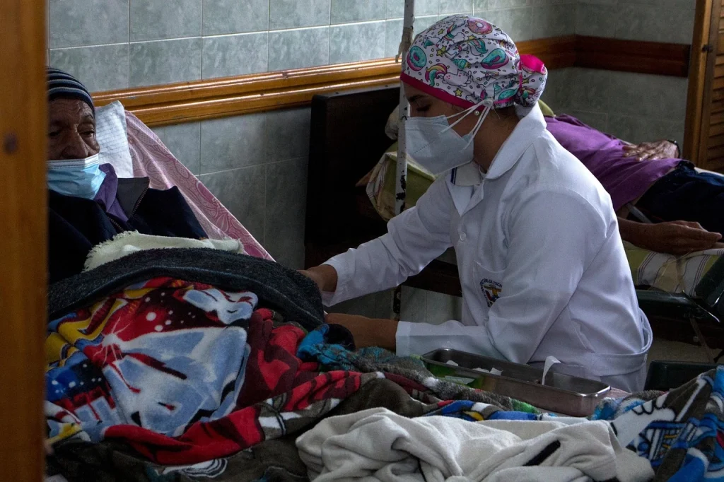 Enfermeira em ambiente hospitalar, abordando as condições de trabalho como matéria de defesa no COREN